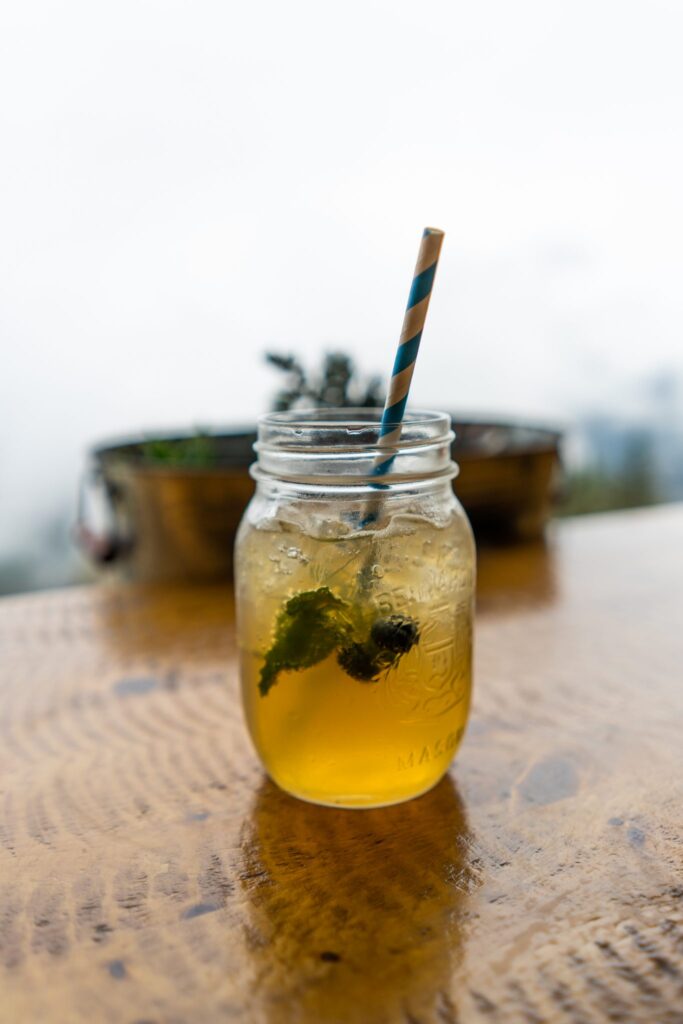 A mason jar mint iced drink at Cliffhouse Bistro, Banff, with a striped straw.